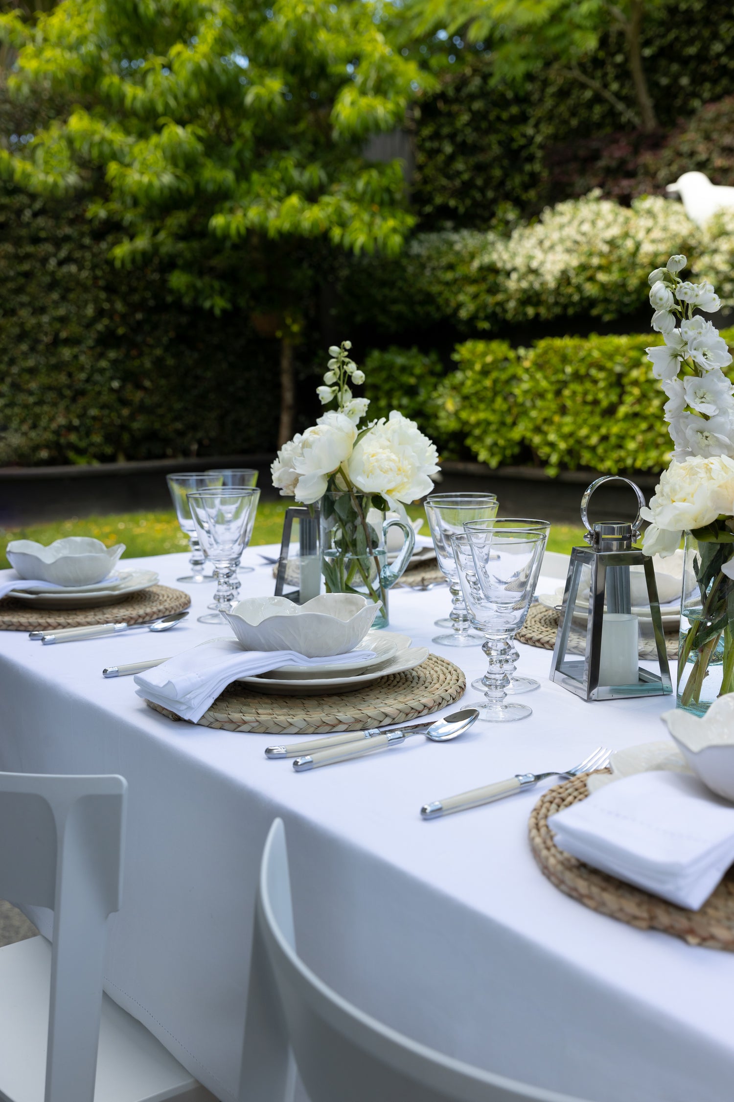 Photo of white tablescape dinner setting with flowers